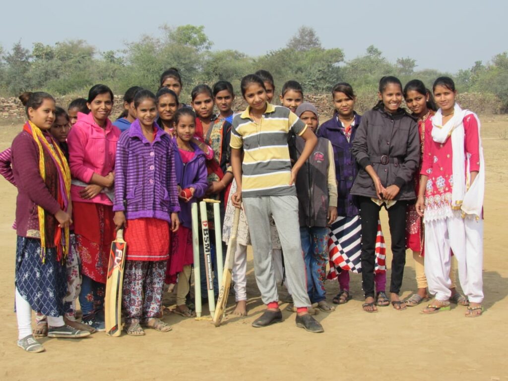 A girls' cricket team posing for the camera, in Budhpura, Rajasthan, India.